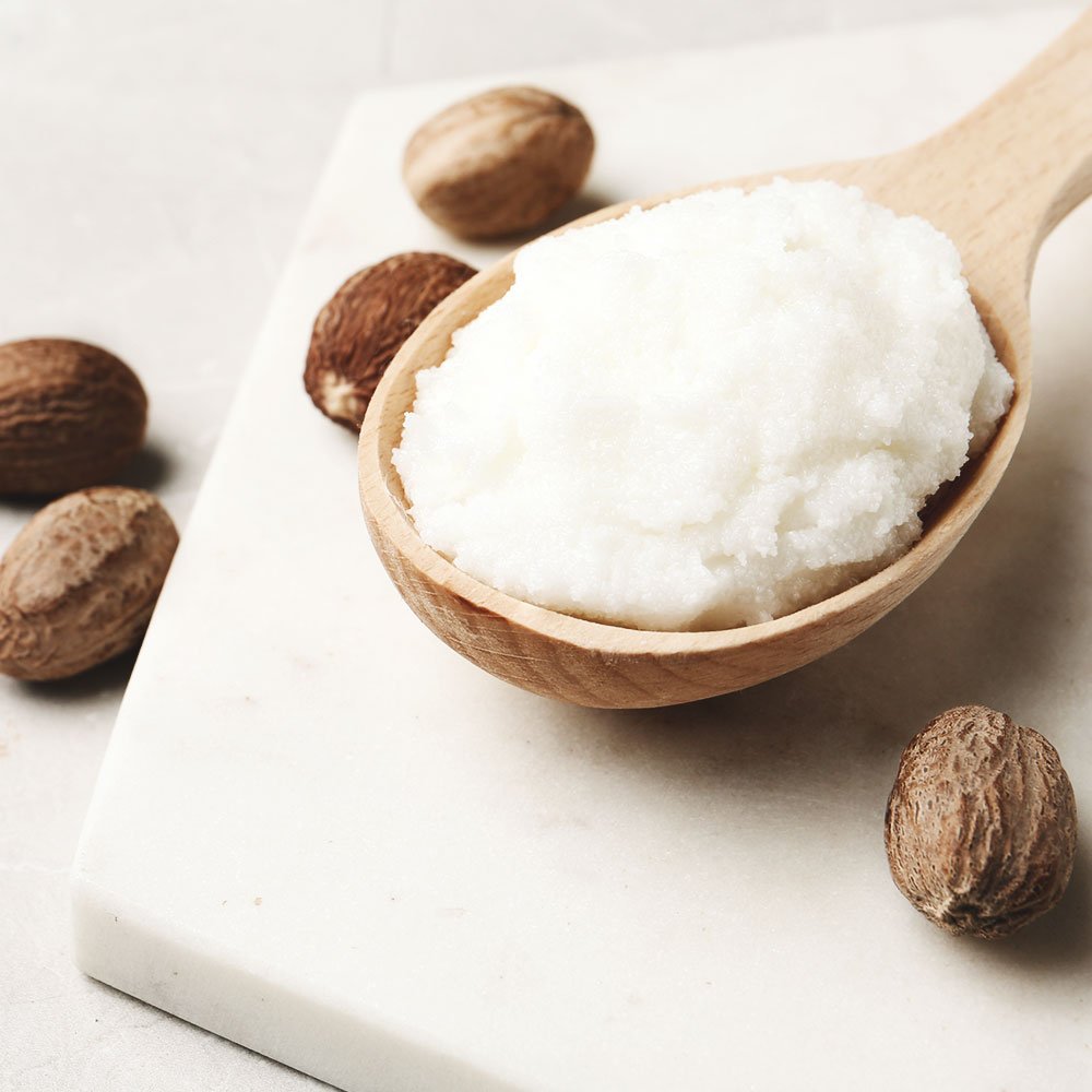 spa butter 1000x1000px Λάδι καρύδας σε ξύλινο κουτάλι και καρύδια.